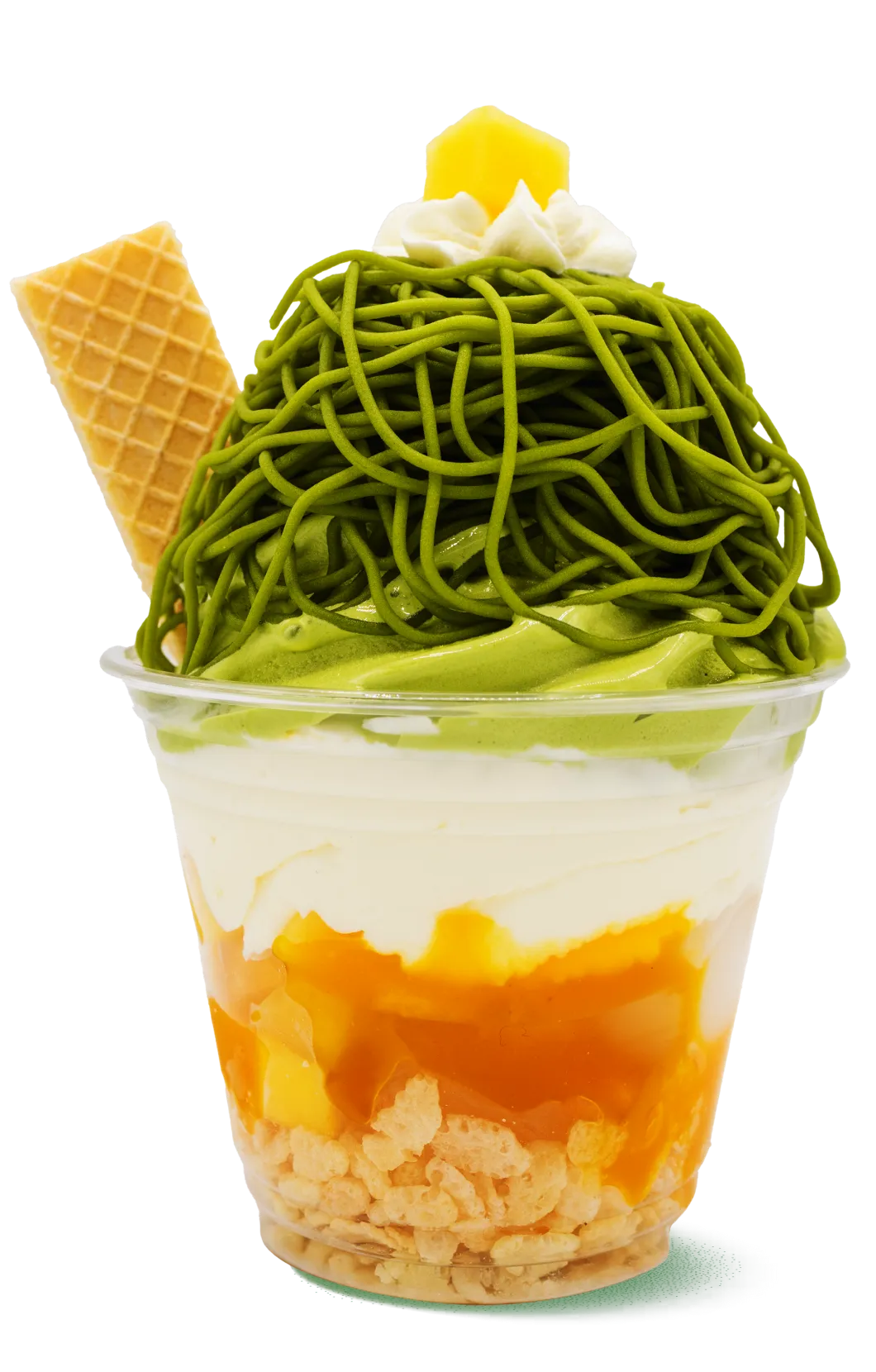Yellow-green layered parfait featuring cereal base with mango sauce, white cream middle, and green matcha noodles on top. Decorated with yellow mango cubes and waffle cone, combining Asian and Western dessert elements.